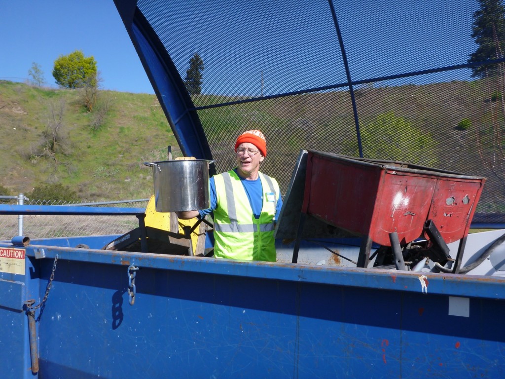 Volunteer in trash dumpster as part of the 2015 spring cleanup.